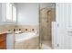 Bathroom with luxurious corner bathtub and elegant tile surround, adjacent to glass shower at 1227 Ashford Creek Ne Park, Atlanta, GA 30319