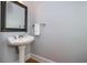 Powder room featuring a pedestal sink, decorative mirror, and neutral wall color at 1227 Ashford Creek Ne Park, Atlanta, GA 30319