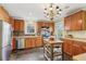 Bright kitchen with stainless steel appliances, wood cabinets, and an island under a decorative chandelier at 1241 Briarcliff Ne Rd, Atlanta, GA 30306
