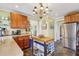Kitchen featuring stainless steel refrigerator, center island, wood cabinets, and decorative hanging light fixture at 1241 Briarcliff Ne Rd, Atlanta, GA 30306