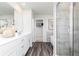 Bright bathroom with dual sinks, white cabinets, and a glass-enclosed shower with tiled walls at 135 Kingsley Way, Acworth, GA 30102