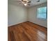 A bright bedroom features hardwood flooring, ceiling fan and a window letting in natural light at 5250 Mountain Village Ct, Stone Mountain, GA 30083