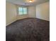 A large bedroom with neutral carpeting and window letting in natural light at 5250 Mountain Village Ct, Stone Mountain, GA 30083