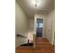 Hallway featuring hardwood floors and view of stairs with dark colored steps at 5250 Mountain Village Ct, Stone Mountain, GA 30083