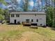 Backyard features a large lawn, treeline, and a deck with access to the home at 212 Lake Forest Dr, Acworth, GA 30102
