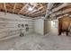 Unfinished basement features exposed ceiling, brick-look wall and installed shelving at 212 Lake Forest Dr, Acworth, GA 30102
