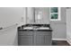 A full bathroom with a double sink vanity, black countertop, and dark stained laminate floors at 212 Lake Forest Dr, Acworth, GA 30102