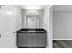 Bathroom with gray vanity, black marble countertop, large mirror, and modern fixtures at 212 Lake Forest Dr, Acworth, GA 30102