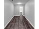 Hallway featuring gray walls and dark-stained wood floors leading to a bright, inviting space at 212 Lake Forest Dr, Acworth, GA 30102