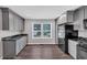Bright kitchen with window, gray cabinets, black appliances, and marble countertops at 212 Lake Forest Dr, Acworth, GA 30102