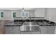 Stainless steel farmhouse sink with black marble countertops and gray cabinets at 212 Lake Forest Dr, Acworth, GA 30102