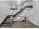 Contemporary staircase featuring dark treads, glass railings, and stylish overhead lighting at 212 Lake Forest Dr, Acworth, GA 30102