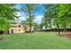 Large, grassy backyard with a wood fence, mature trees, and a deck at 2929 Alberta Dr, Marietta, GA 30062
