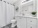 Well-maintained bathroom with a shower curtain, vanity, mirror, and decorative plant at 2929 Alberta Dr, Marietta, GA 30062