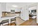 Classic white kitchen features stone countertops and breakfast bar seating and opens to the living room at 2929 Alberta Dr, Marietta, GA 30062