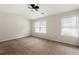 Spacious bedroom features carpet, two windows with white blinds, and a ceiling fan at 4100 Howell Park Rd, Duluth, GA 30096