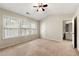 A bright bedroom with three windows, carpet flooring, and a bathroom entrance at 4100 Howell Park Rd, Duluth, GA 30096