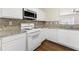A bright kitchen features white cabinets, granite countertops, and stainless steel appliances at 4100 Howell Park Rd, Duluth, GA 30096