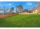 This large fenced backyard features a lush lawn and mature trees, perfect for outdoor activities at 4806 Forest Trl, Douglasville, GA 30135