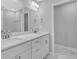 Bathroom featuring double sinks, white cabinets, large mirrors, and modern lighting fixtures at 4806 Forest Trl, Douglasville, GA 30135