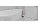 Bathroom featuring a modern freestanding tub, white marble flooring, and a sleek door at 4806 Forest Trl, Douglasville, GA 30135