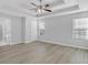 Large primary bedroom with tray ceiling, ceiling fan, and hardwood floors at 4806 Forest Trl, Douglasville, GA 30135