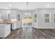 Dining area with hardwood floors and sliding glass doors, next to the kitchen with white cabinets at 4806 Forest Trl, Douglasville, GA 30135