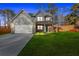 Charming two-story home featuring gray siding, a brick-accented porch, and a two-car garage at 4806 Forest Trl, Douglasville, GA 30135
