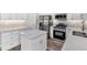 Bright kitchen featuring white cabinetry, stainless steel appliances, island, and stone backsplash at 4806 Forest Trl, Douglasville, GA 30135