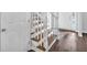 Wooden staircase with white banister and hardwood floors, leading to an entry door at 4806 Forest Trl, Douglasville, GA 30135