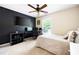 Modern bedroom features a black accent wall, large TV, and desk setup for gaming or work at 935 Mill Creek Ave, Canton, GA 30115