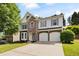Beautiful two-story home featuring a stone facade, bay window, and an attached two-car garage at 935 Mill Creek Ave, Canton, GA 30115