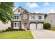 Charming two-story home with stone accents, a well-manicured lawn, and a two-car garage at 935 Mill Creek Ave, Canton, GA 30115