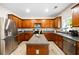 Eat-in kitchen showcasing stainless steel appliances, wood cabinetry, granite countertops, and large center island at 935 Mill Creek Ave, Canton, GA 30115