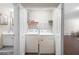 Convenient laundry closet with washer, dryer, and shelving for storage next to the bathroom at 935 Mill Creek Ave, Canton, GA 30115