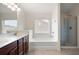 Bathroom features a double sink vanity, large mirror, soaking tub and a glass enclosed shower stall at 1957 Brightleaf Way # 59, Marietta, GA 30060