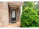 Close up of entryway with black front door, sidelight, and lush green bush at 1957 Brightleaf Way # 59, Marietta, GA 30060