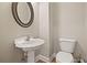 Small half bathroom with a toilet, sink, oval mirror and light beige walls at 3133 Dunton Se St, Smyrna, GA 30080