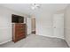 Bedroom with light grey walls and trim, carpet floors, and a wooden dresser with a large television at 3133 Dunton Se St, Smyrna, GA 30080