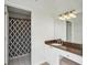 Well-lit bathroom featuring vanity with stone counters, a shower with patterned curtain and neutral tiling at 3475 Oak Valley Ne Rd # 2060, Atlanta, GA 30326