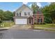 Two-story home with brick and gray siding, attached garage, manicured lawn, and mature trees at 3513 Newtons Crest Cir, Snellville, GA 30078