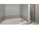 Bathroom featuring a tub, separate shower, and tile surround, creating a clean and modern space at 4023 Caitlyn Pl, Atlanta, GA 30360