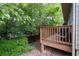 An outdoor wooden deck surrounded by lush greenery and trees at 4023 Caitlyn Pl, Atlanta, GA 30360