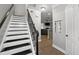 Bright hallway with staircase featuring black metal railings and hardwood floors at 4023 Caitlyn Pl, Atlanta, GA 30360