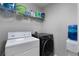 Functional laundry area equipped with modern washer, dryer, storage shelves, and a water dispenser at 4023 Caitlyn Pl, Atlanta, GA 30360