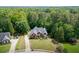Overhead view of a brick home with pristine landscaping, situated among mature trees and green surroundings at 4530 Bogan Gates Dr, Buford, GA 30519