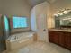 Relaxing bathroom with large soaking tub, shower, granite counters and tiled floor at 4530 Bogan Gates Dr, Buford, GA 30519