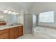 Elegant bathroom featuring a corner jacuzzi, walk-in shower and vanity with granite countertops at 4530 Bogan Gates Dr, Buford, GA 30519