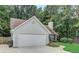 Exterior view highlighting the two-car garage, siding, and mature trees surrounding the property at 169 Parkside Dr, Stockbridge, GA 30281