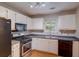 Functional kitchen with white cabinets, stainless steel appliances, and ample counter space at 169 Parkside Dr, Stockbridge, GA 30281